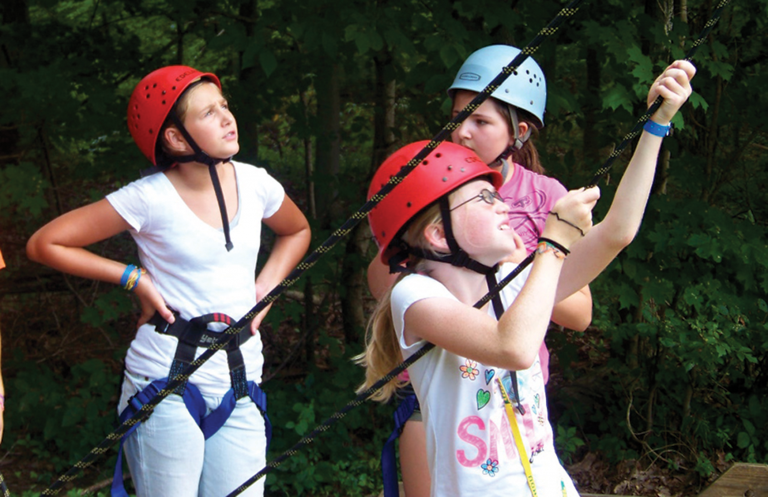 Campers check the ropes before beginning their next challenge.