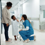 Black family, healthcare and a pediatrician talking to a patient in the hospital for medical child care. Kids, trust or medicine and a nurse consulting a boy with his mother in the clinic for health.